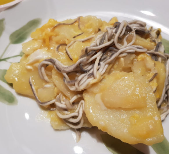 Huevos rotos con patatas y gulas.