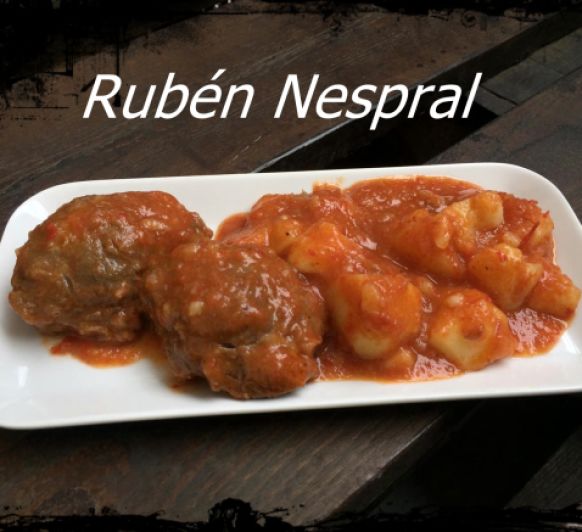 Carrilleras en salsa con pimientos rojos y guarnición de patatas.